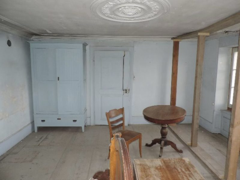 La chambre bleue avec des étais pour supporter la poutre qui est pourrie suite à une infiltration d’eau dans la couverture du toit